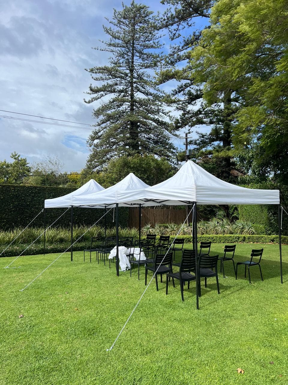 Premium white gazebos set up in a garden with seating